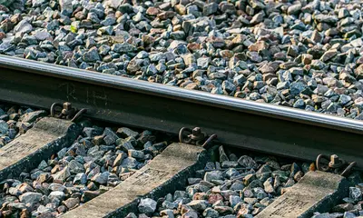 Eine Bahnschiene auf einem geschotterten Gleisabschnitt.