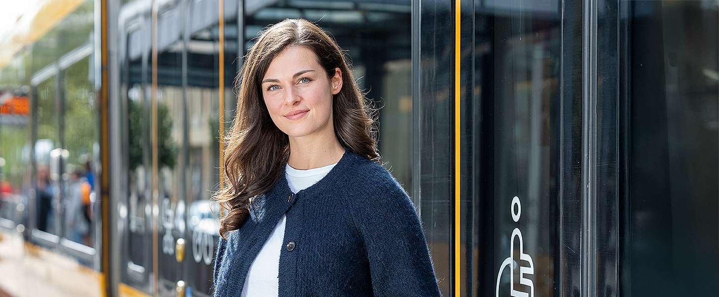 Eine junge Frau steigt aus der Bahn.