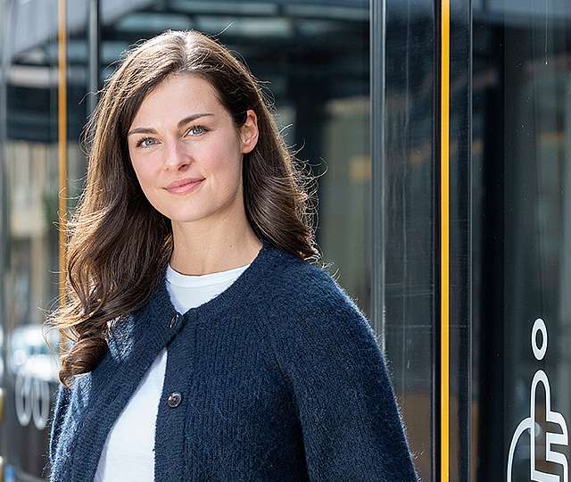 Eine junge Frau steigt aus der Bahn.