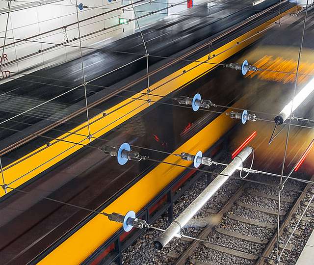 Zwei Bahnen fahren an einer Haltestelle aneinander vorbei.