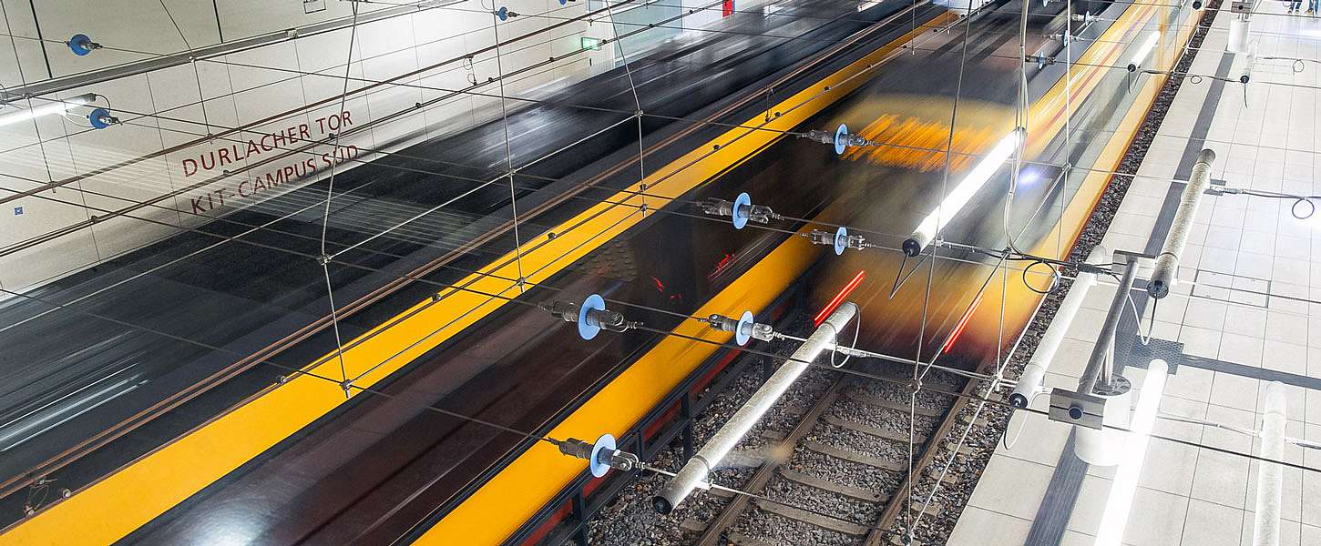 Zwei Bahnen fahren an einer Haltestelle aneinander vorbei.