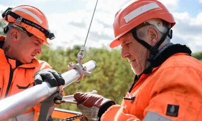 Zwei Mitarbeiter der Deutschen Bahn reparieren eine Oberleitung